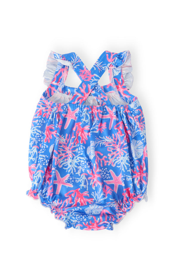 coral print baby romper in blue with pink sea creatures and white ruffle cross back for infants