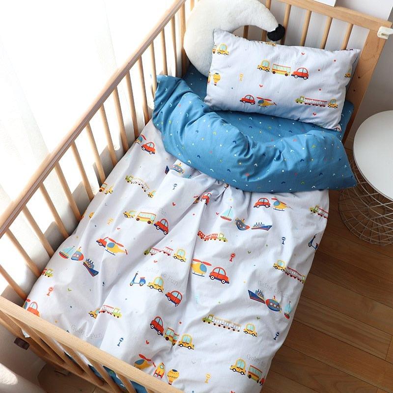 Colorful crib bedding with vehicle patterns and blue polka dot blanket in nursery crib for infants