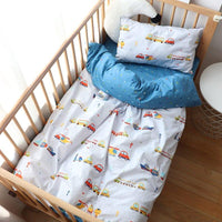 Colorful crib bedding with vehicle patterns and blue polka dot blanket in nursery crib for infants