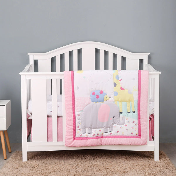 White baby crib with pink and pastel animal-themed crib bedding for infants with elephant and giraffe design