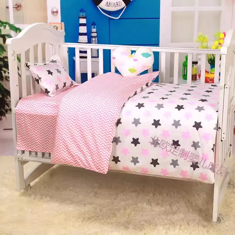 White baby crib with pink and gray star pattern crib bedding set for newborn nursery