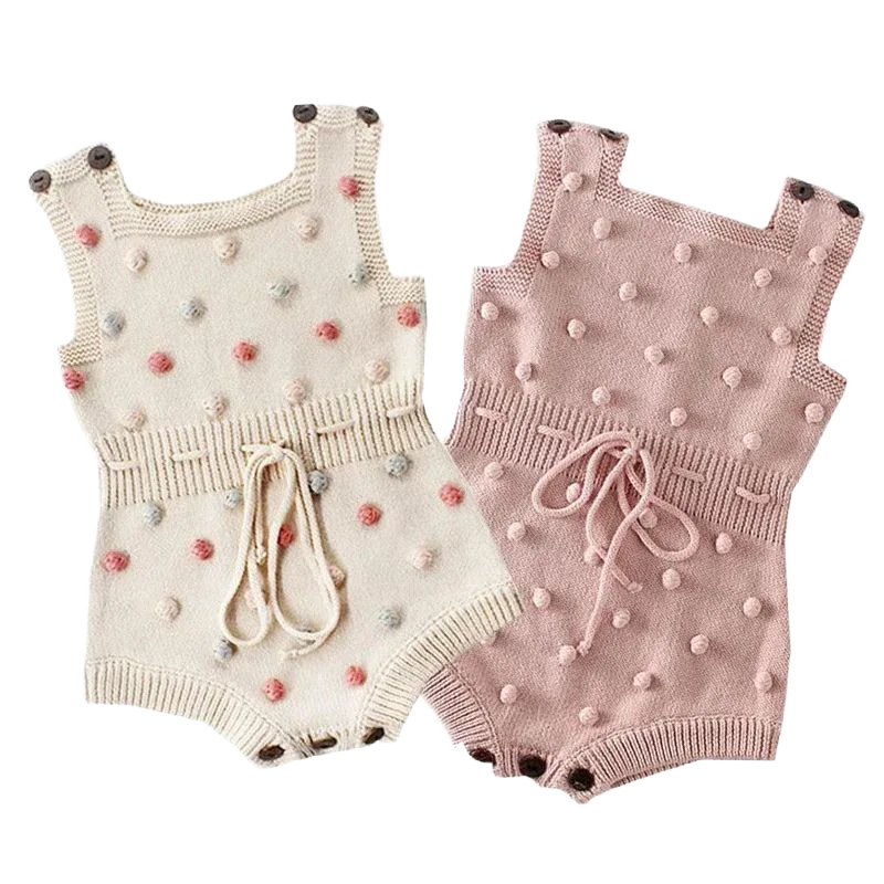 Cute knit baby romper in cream and pink for infants with pom pom details and waist ties