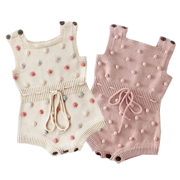 Cute knit baby romper in cream and pink for infants with pom pom details and waist ties
