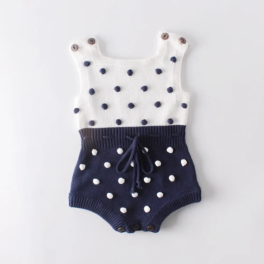 Cute knit baby romper in white and navy with polka dots and button straps for infants