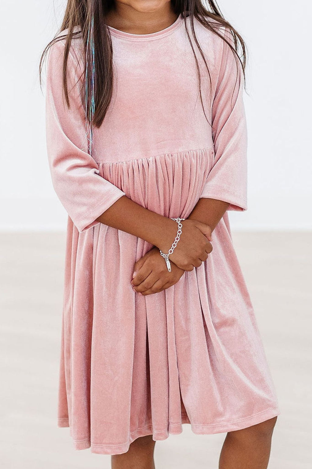 Girl wearing a Vintage Pink Velvet Twirl Dress, standing with arms crossed, showcasing the elegant design and soft fabric.