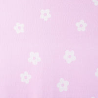 Macro view of repeating white five-petal daisies with pink centers evenly spaced across light pink 100% cotton jacquard