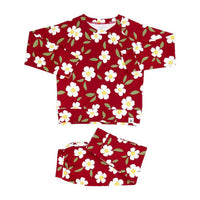 Red floral kids crew neck jogger set with white flowers, green leaves, and matching pants for cozy all-day comfort.