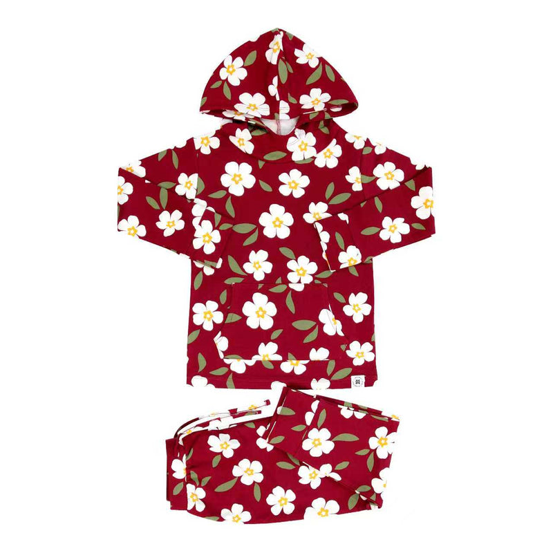 Red floral children's hooded jogger set with front pocket, featuring white flowers and green leaves on maroon fabric.
