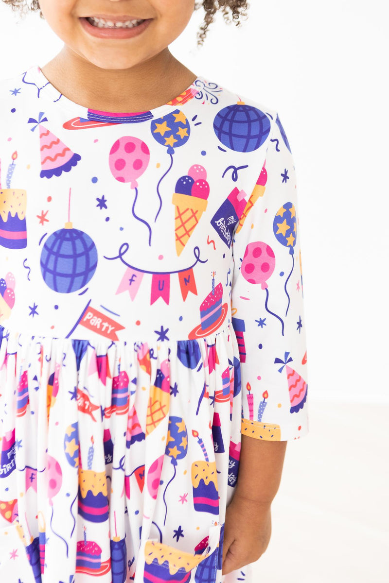 Happy Birthday 3/4 Sleeve Pocket Twirl Dress on a smiling girl with fun party prints, perfect for celebrations!