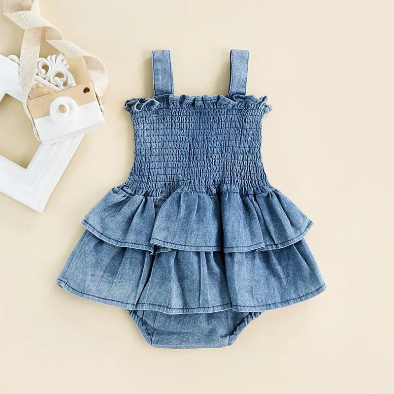 blue denim baby romper with smocked bodice and ruffle skirt for infants