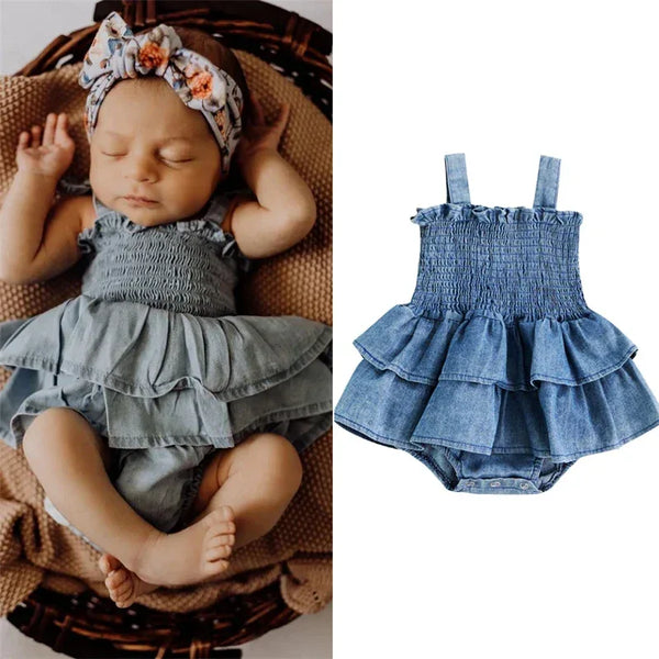 Denim blue baby romper for infants with ruffled skirt and smocked bodice