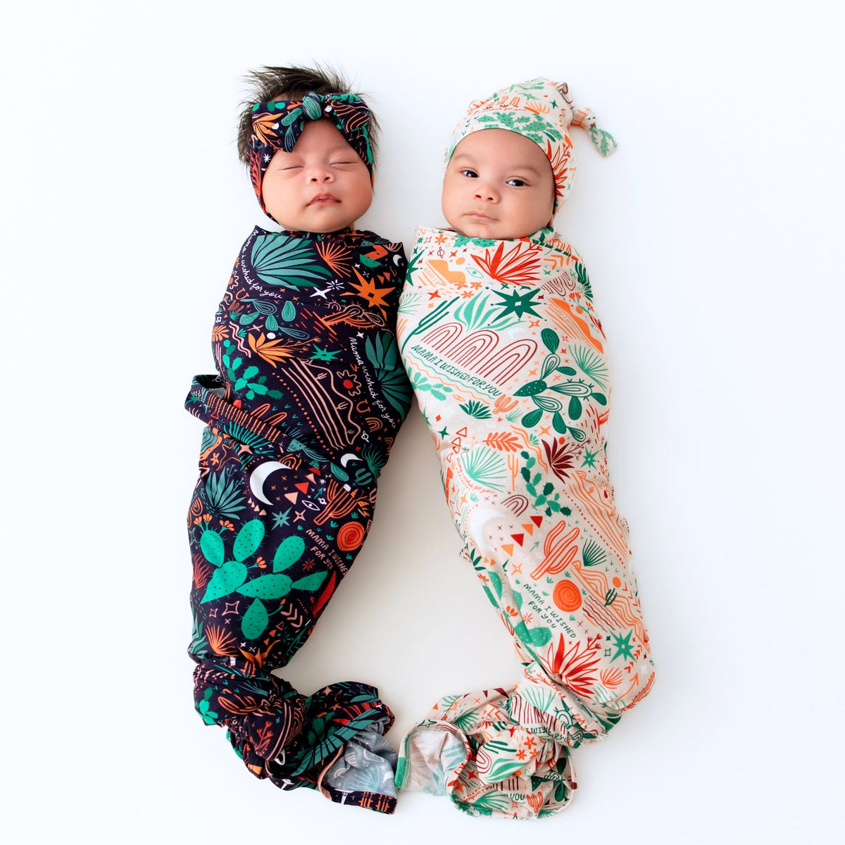 Two babies swaddled in The Forever Swaddle Blanket Desert Cactus Midnight, showcasing bold cactus prints.