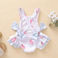 White dessert themed baby swimsuit with pink cupcake prints and blue ruffle bows for infants