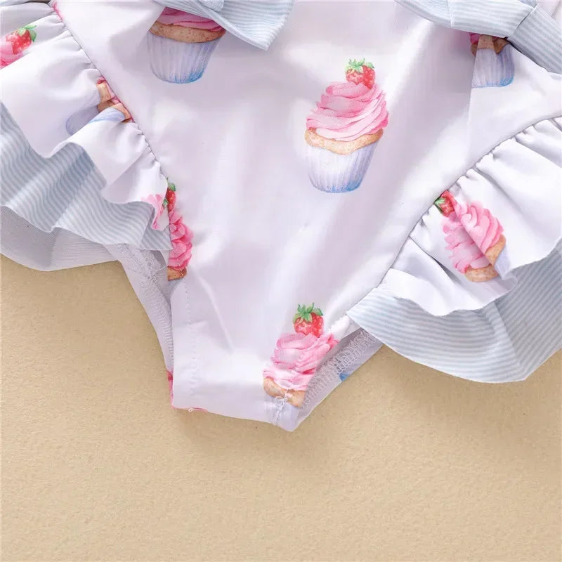 White dessert themed baby swimsuit with pink cupcake print and ruffle details for infants
