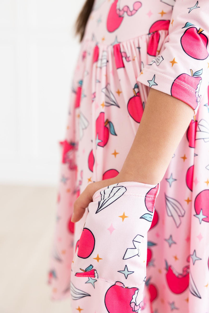 Close-up of the Star Student 3/4 Sleeve Pocket Twirl Dress by Mila & Rose®, featuring detailed print with apples and stars, highlighting the playful pocket design.
