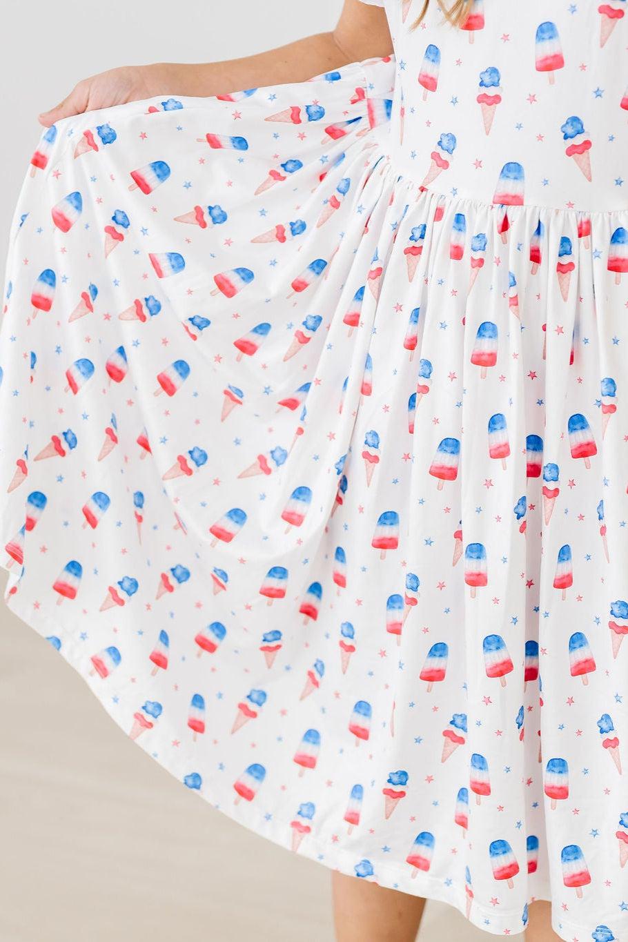 Girls white twirl dress for the summer with red blue popsicle print and flutter sleeves