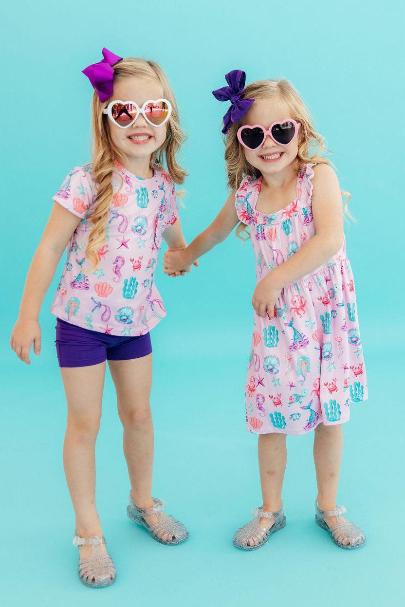 Girls light pink ruffle cross back dress ruffle with colorful sea creature print for toddlers