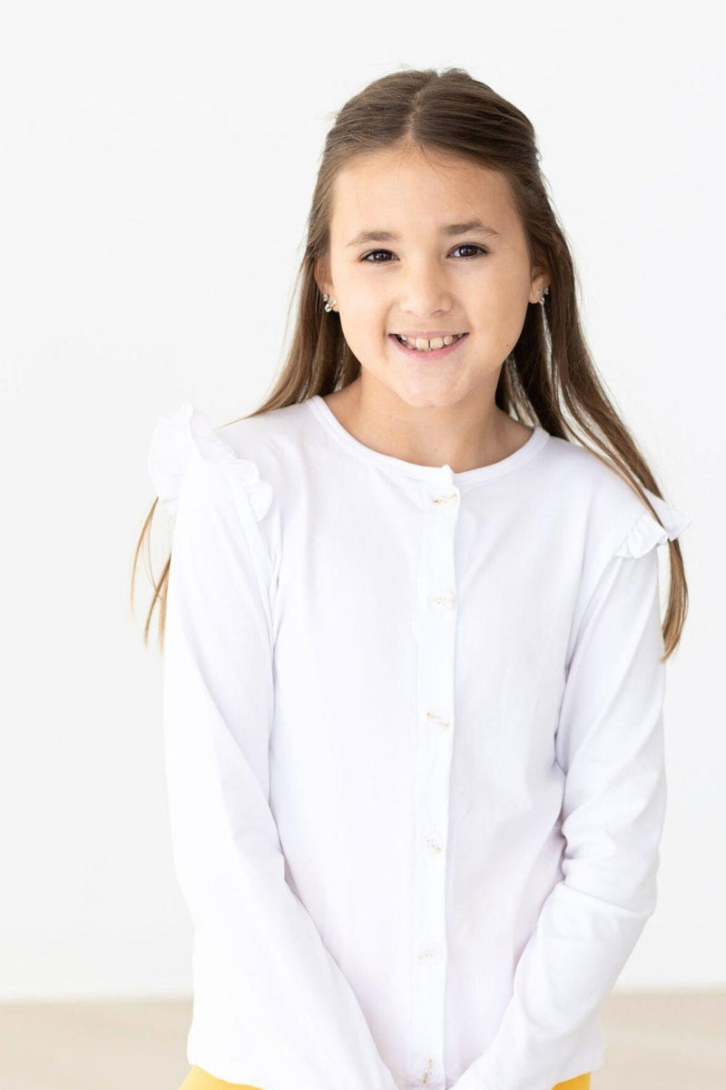 Happy girl in a White Ruffle Cardigan by Mila & Rose®, featuring cute ruffle accents, ideal for adding a stylish layer to any outfit while ensuring comfort.