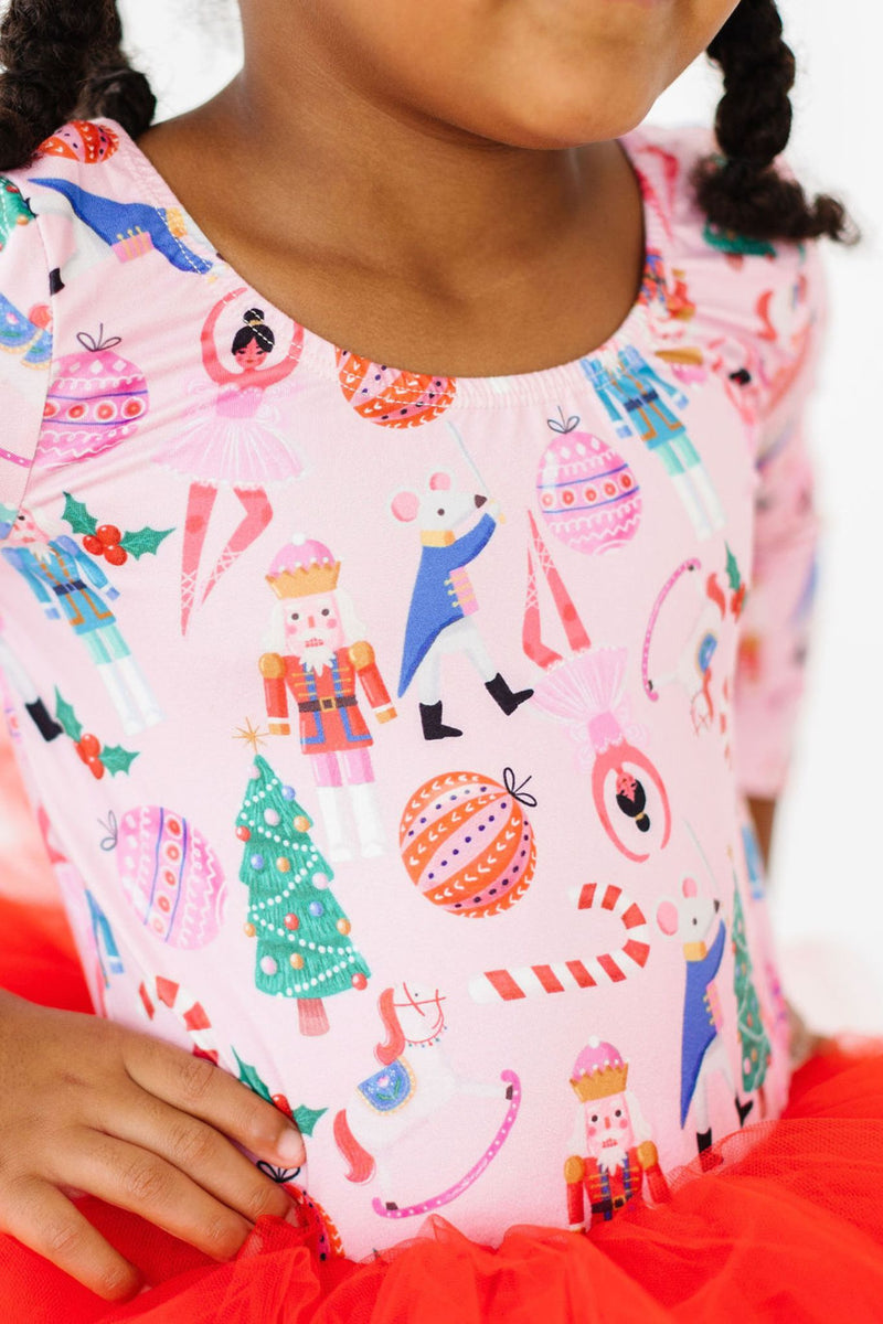 Close-up of a smiling child in the Sugarplum Fairy 3/4 Tutu Leotard by Mila & Rose®, showcasing the playful holiday-themed design on a soft fabric.