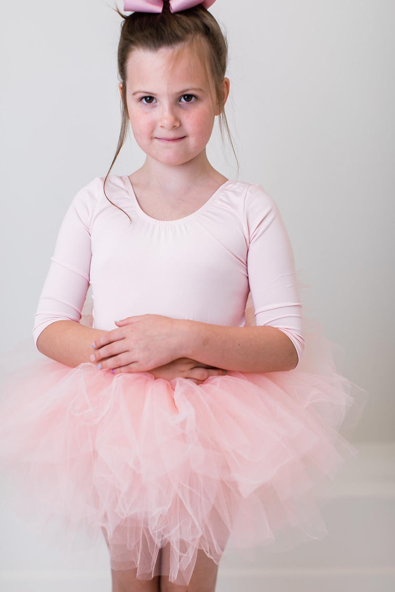 Girl's Ballet Pink 3/4 Tutu Leotard worn by a young dancer, radiating joy as she spins gracefully.