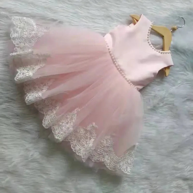 pink elegant baby girl party dress with pearl trim and lace hem for toddlers on hanger