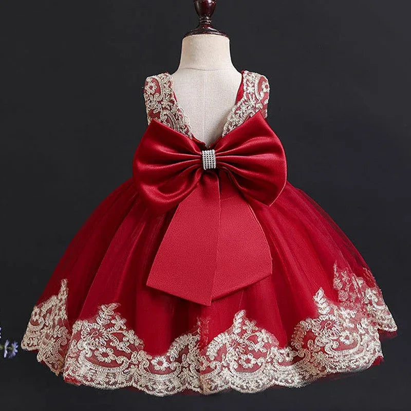 elegant baby girl party dress in deep red with lace trim and large bow on mannequin