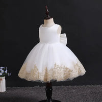 elegant baby girl party dress in white with gold lace trim on mannequin for toddlers