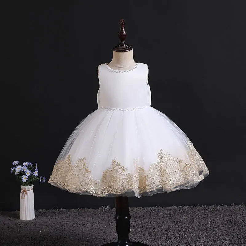 elegant baby girl party dress in white with gold lace trim displayed on mannequin