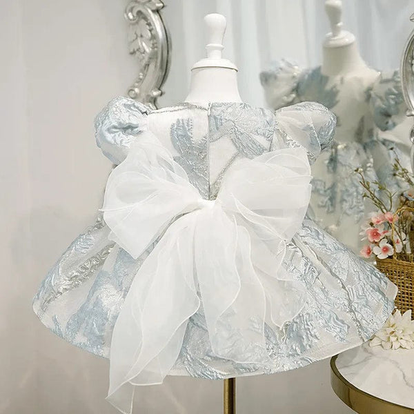 little girls elegant baby brocade dress in light blue with puff sleeves and large white bow