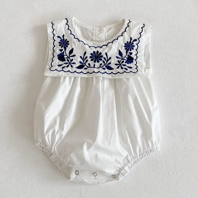 White embroidered baby romper with sailor collar featuring navy blue floral embroidery for infants
