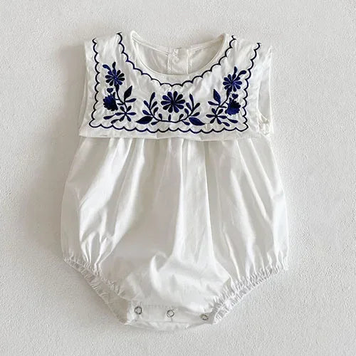 white baby romper with navy blue embroidered flowers and scalloped sailor collar for infants