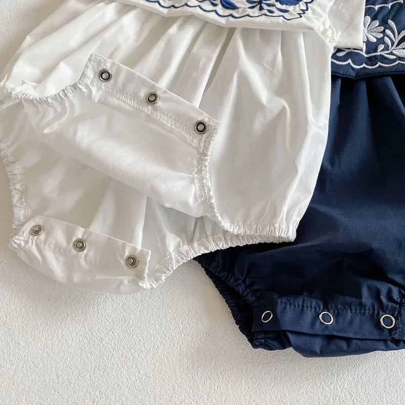 white and navy embroidered baby romper with sailor collar, snap closures, suitable for infants