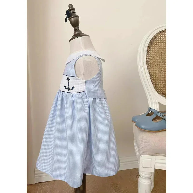 blue gingham embroidered girls party dress on toddler mannequin with anchor detail