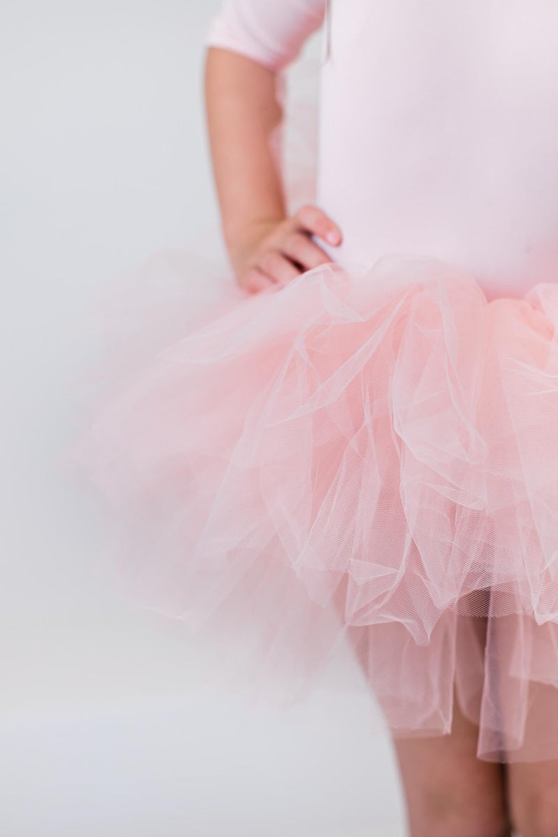 Girl's Ballet Pink 3/4 Tutu Leotard draped elegantly to showcase its fluffy layers for twirling in style.