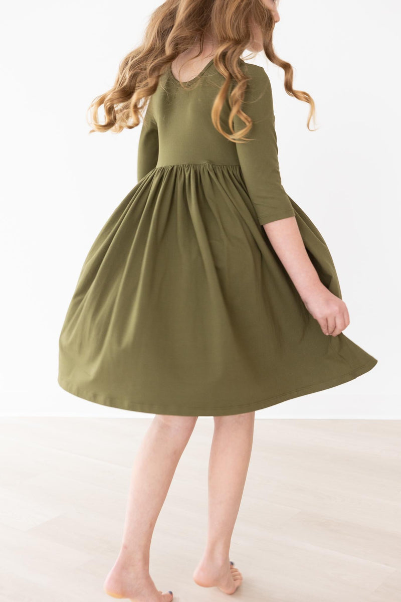 Back view of the Olive 3/4 Sleeve Pocket Twirl Dress by Mila & Rose, with a little girl in motion, emphasizing the dress's scoop back and flowing skirt.