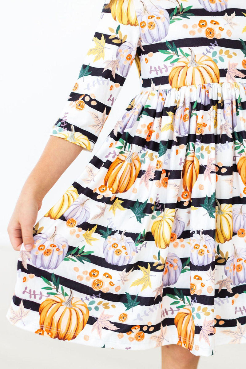 The Pumpkins & Peonies 3/4 Sleeve Pocket Twirl Dress displayed hanging, showcasing its soft polyester and spandex fabric with vibrant patterns.