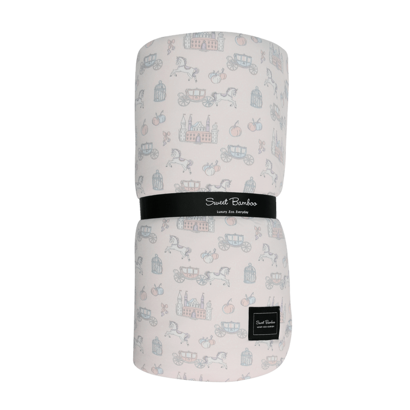 Folded baby blanket with vehicle pattern and Sweet Bamboo label on a green background
