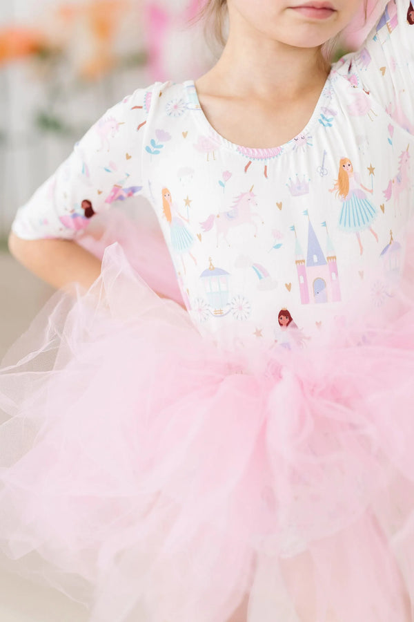 Young girl wearing Mila & Rose fairy princess tutu leotard for girls in pink posing with arms raised