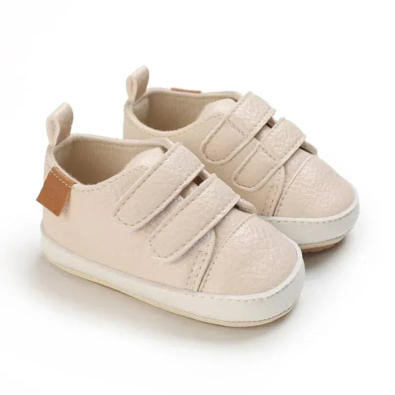 Beige faux leather baby shoes for infants with double velcro straps and soft soles