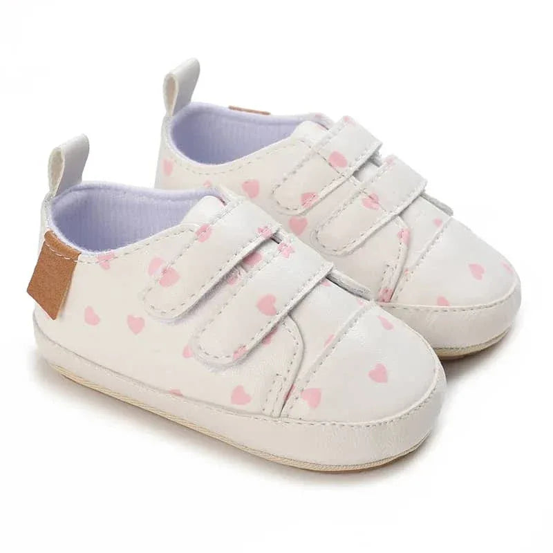 White faux leather baby shoes with pink hearts and velcro straps for infants