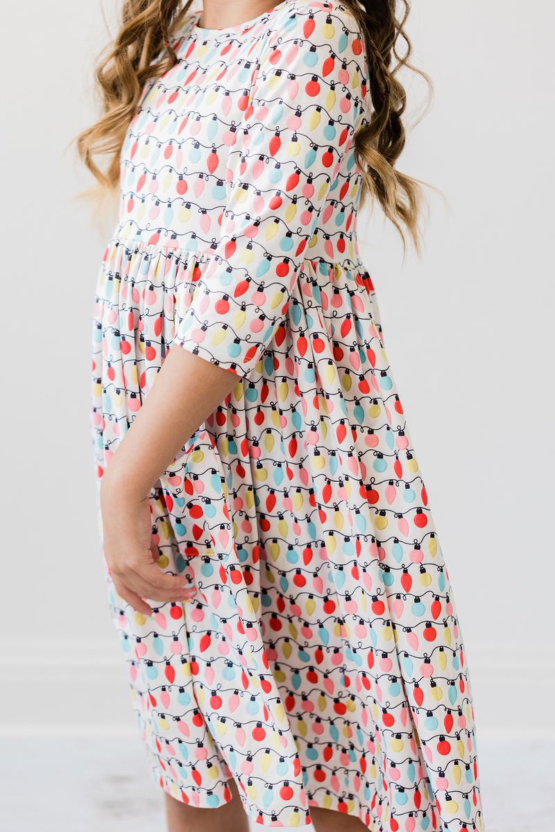 Side view of the Merry & Bright 3/4 Sleeve Pocket Twirl Dress, highlighting its vibrant lights design and playful twirl skirt perfect for dress-up occasions.