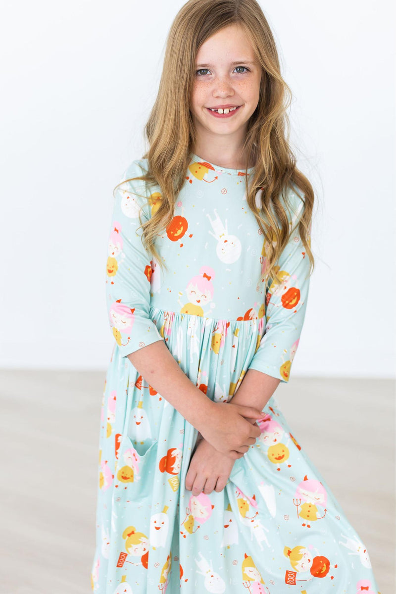 Close-up of a girl in a Ghouls Just Want to Have Fun 3/4 Sleeve Pocket Twirl Dress, showing off its colorful character print and twirling design—ideal for little fashionistas!