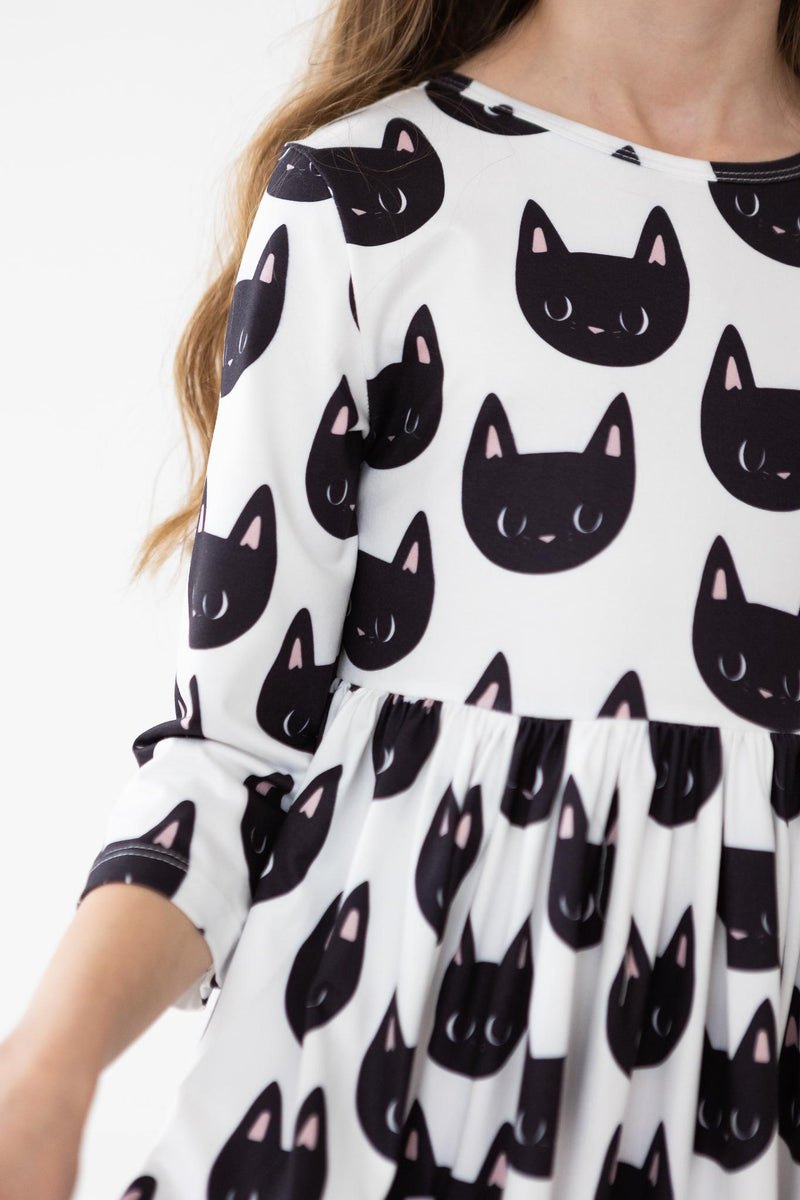 Close-up view of the Purrfect 3/4 Sleeve Pocket Twirl Dress by Mila & Rose, showcasing the cute black cat pattern and soft fabric.
