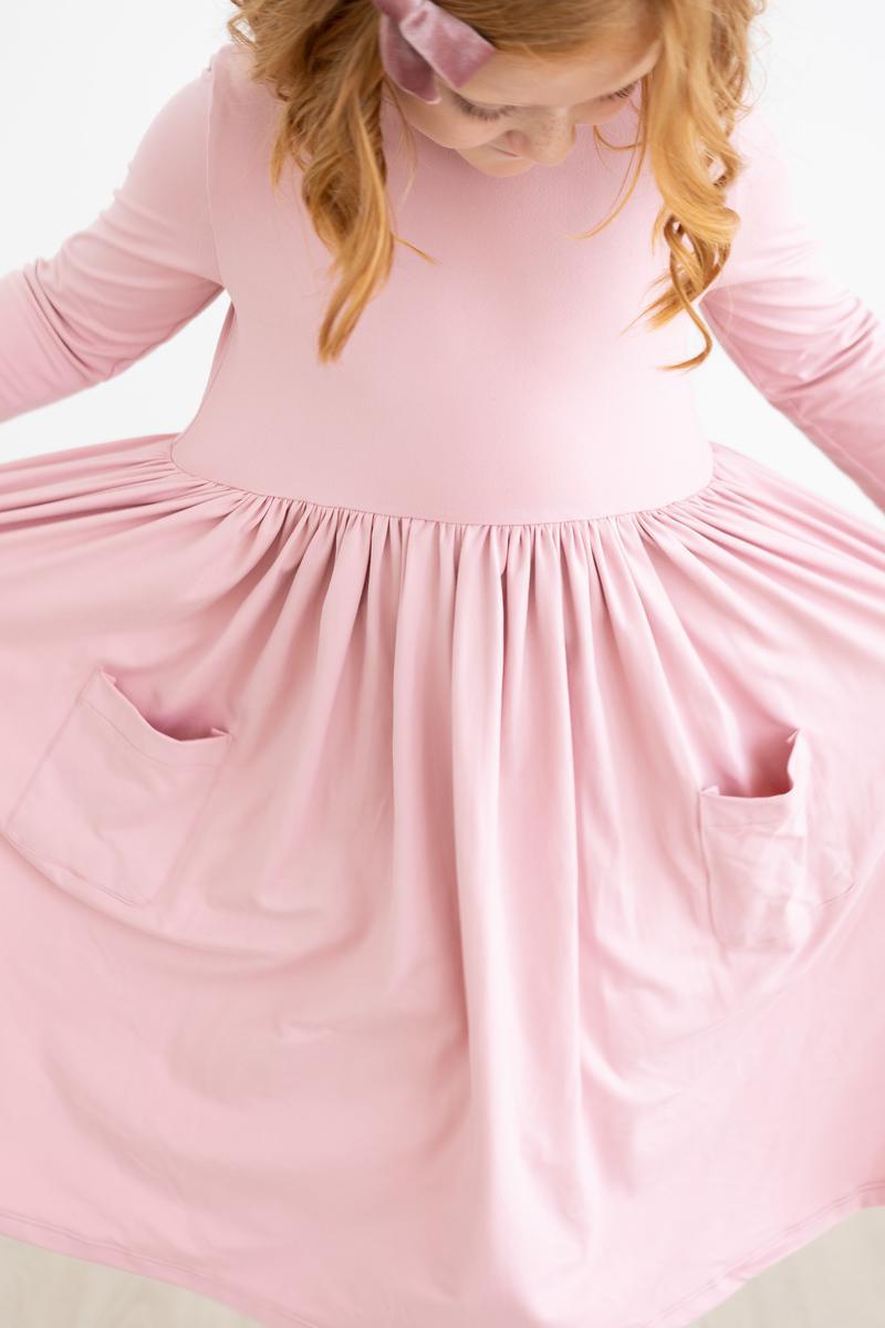 Close-up of the Vintage Pink 3/4 Sleeve Pocket Twirl Dress featuring gathered skirt and pockets, perfect for playful moments.