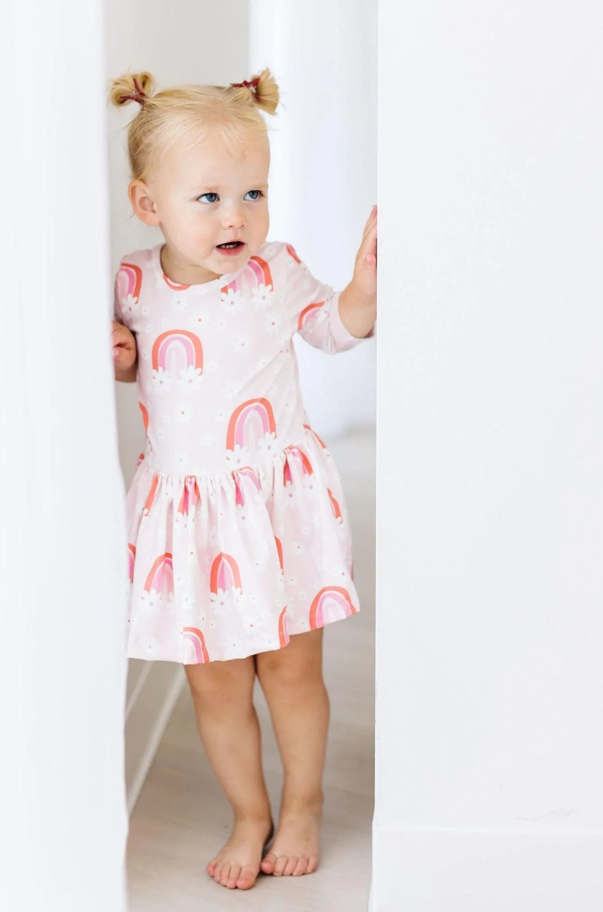 Toddler girl wearing pink 3/4 sleeve floral baby bodysuit dress with rainbow print by Mila & Rose