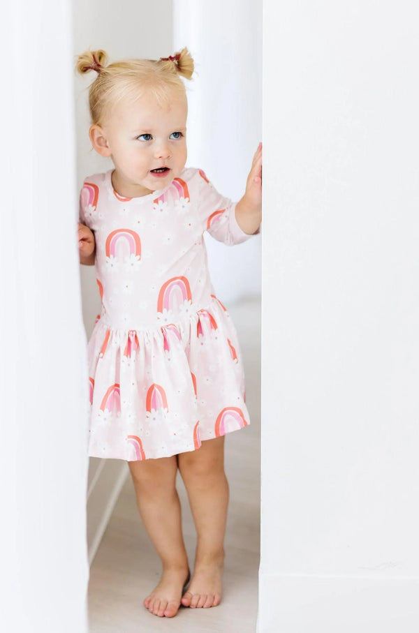 Toddler girl wearing pink 3/4 sleeve floral baby bodysuit dress with rainbow print by Mila & Rose