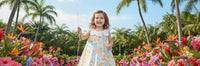 Another view of a joyful little girl in the "Little Selena" A-Line Floral Dress with Petal Collar, smiling in a colorful floral backdrop, ideal for warm-weather celebrations.