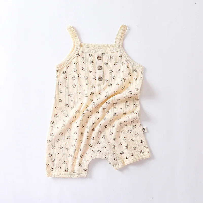 cream floral baby romper for infants with thin straps and wooden button detail front