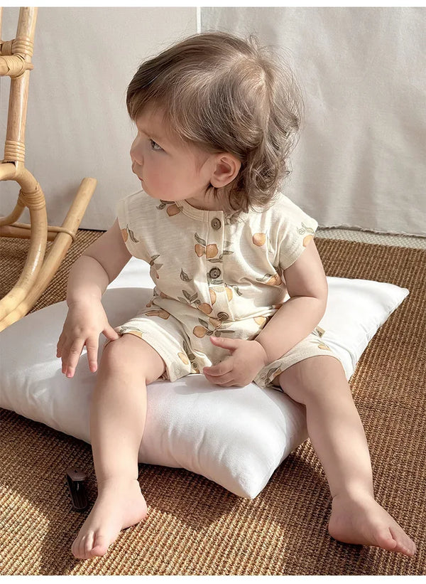 Cream floral baby romper for infants with short sleeves and button front closure