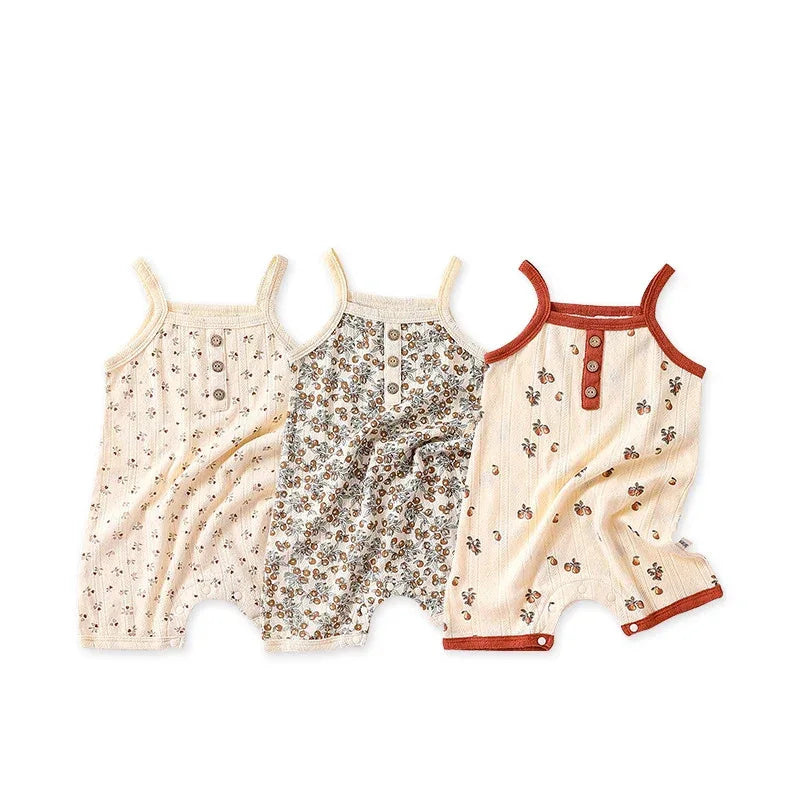 Set of three floral baby romper outfits in cream and brown colors with button details for infants